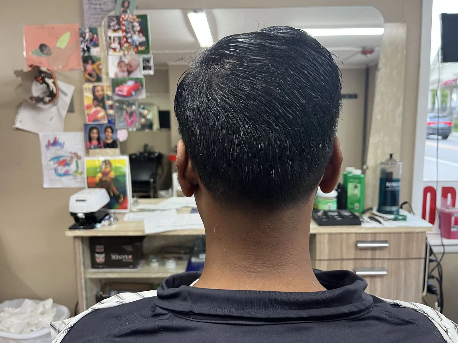 Back of a man's head showing short salt-and-pepper hair and a clean tapered neckline