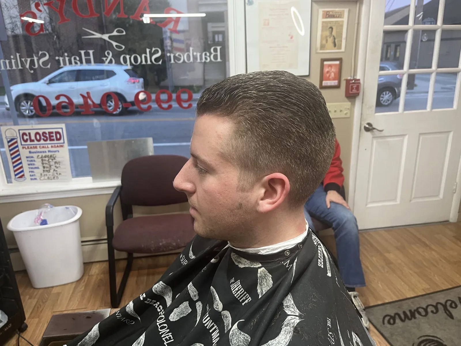 Side profile of a young man with a short slicked top and tapered sides
