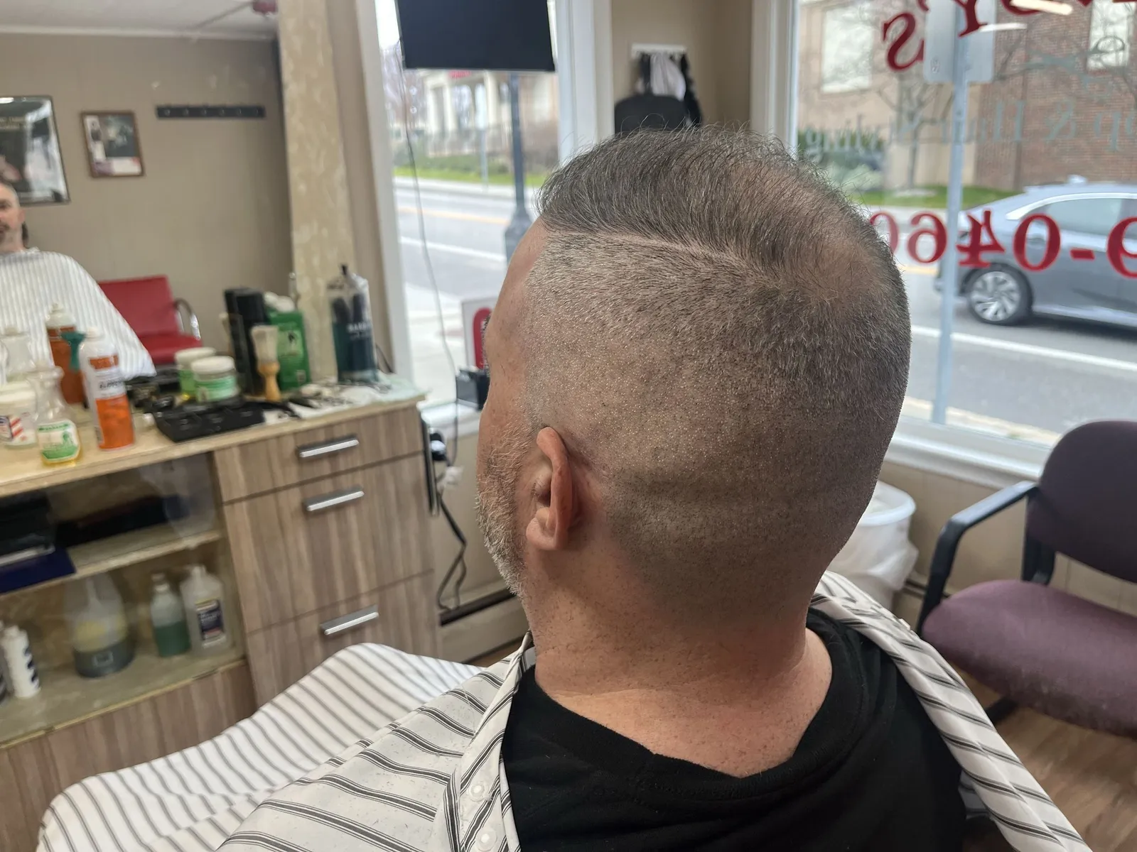 Side of a man's head with a shaved hard part and a high skin fade