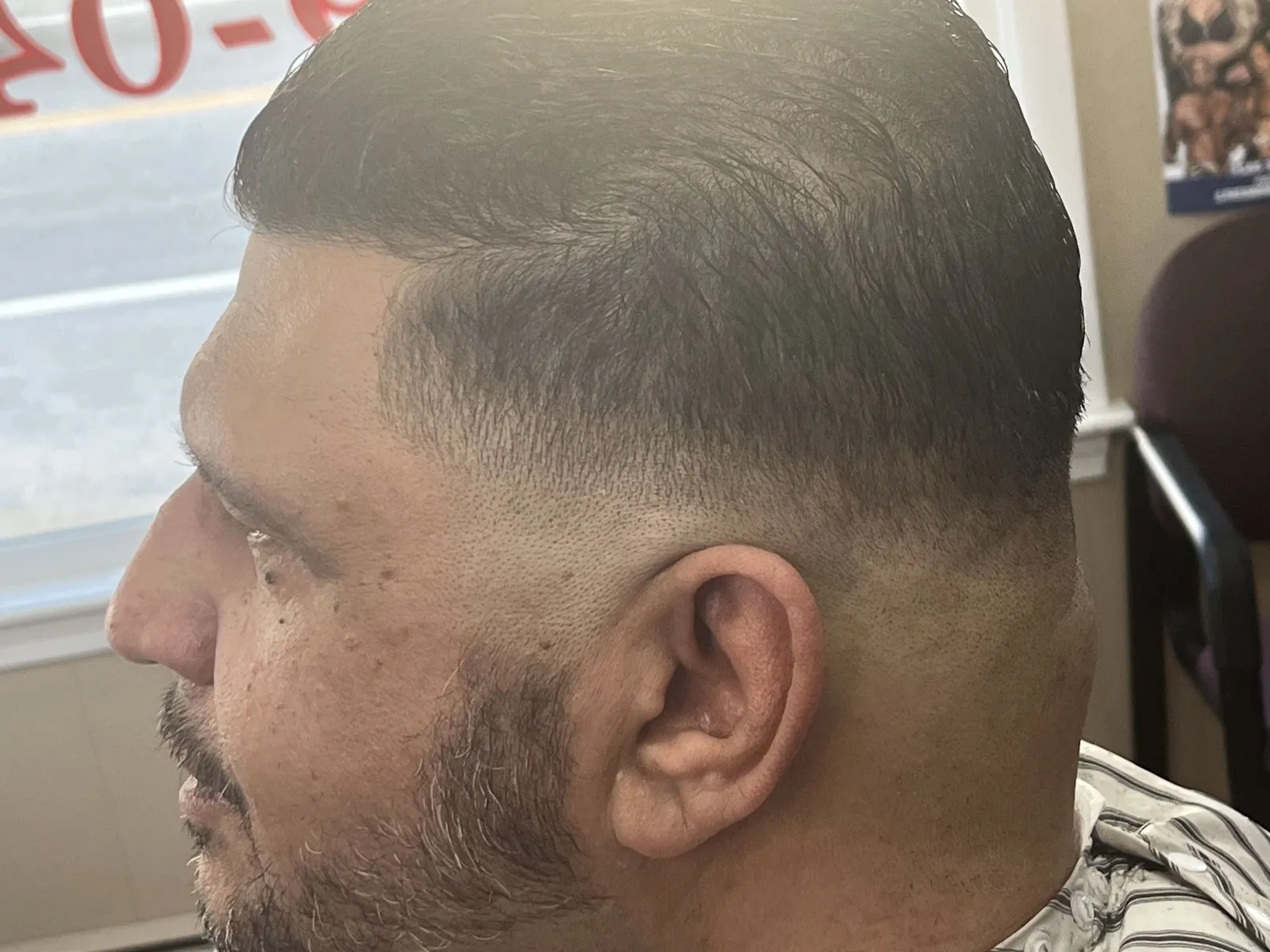 Close side view of a short textured cut with a low skin fade and a beard