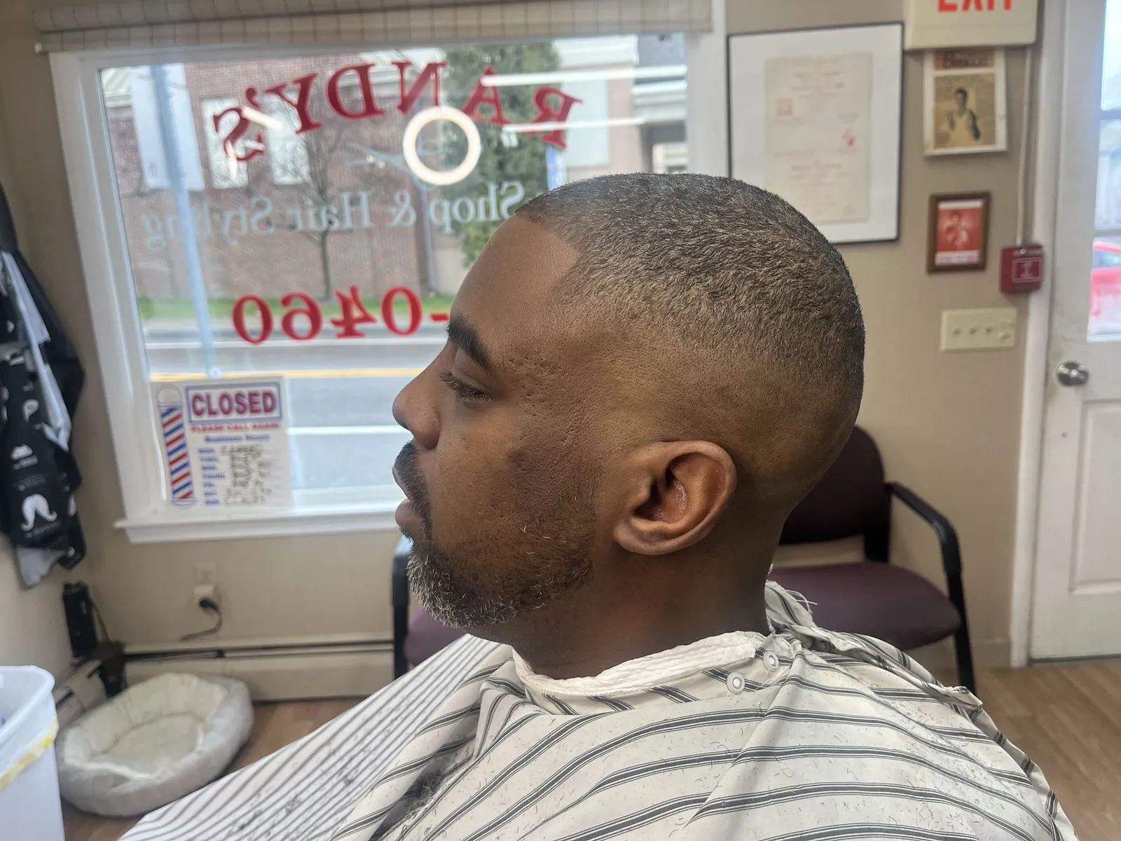 Side profile of a man with a buzz cut, a skin fade and a grey-flecked beard
